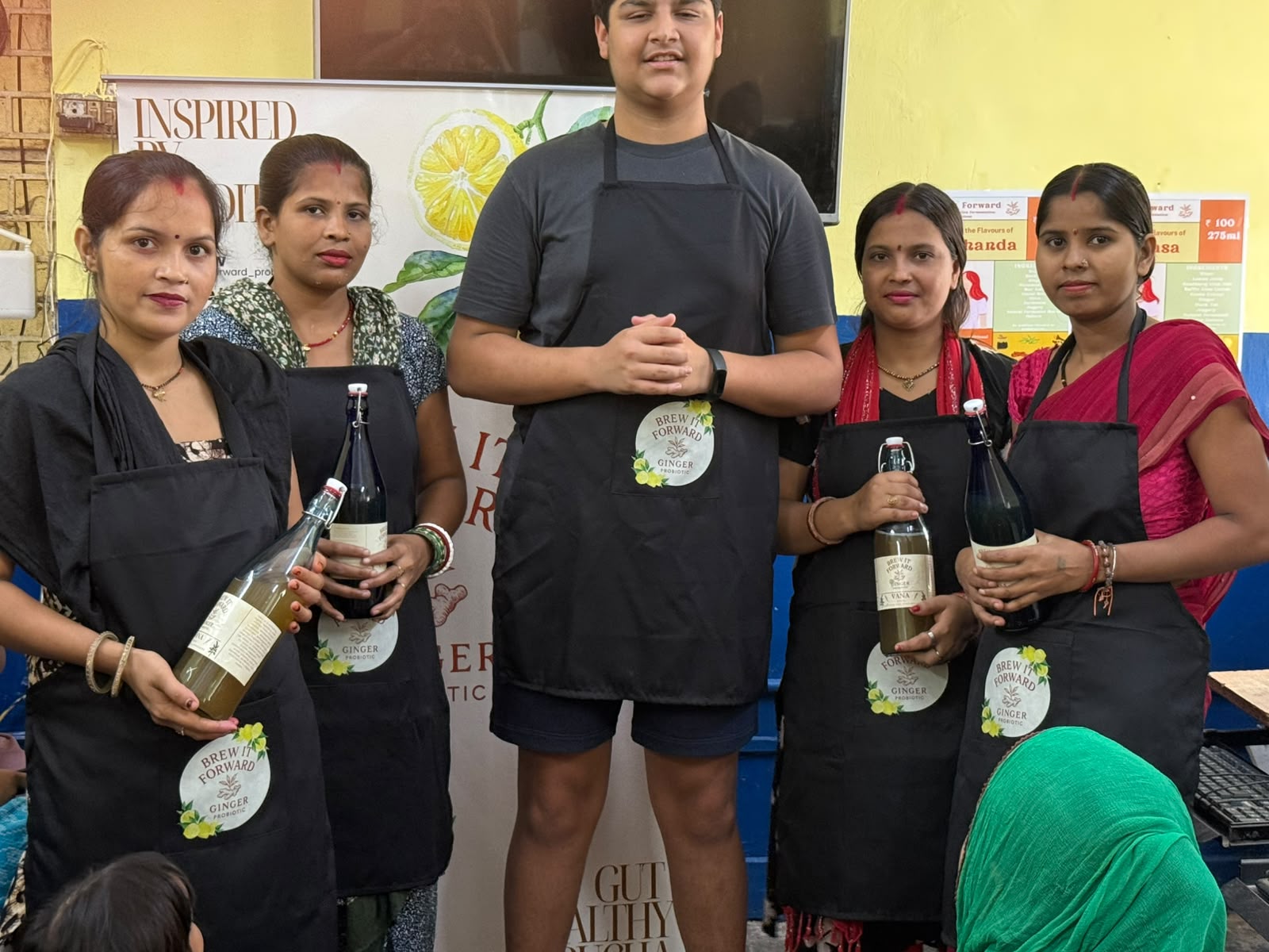 Women holding Brew It Forward bottles after a fermentation session