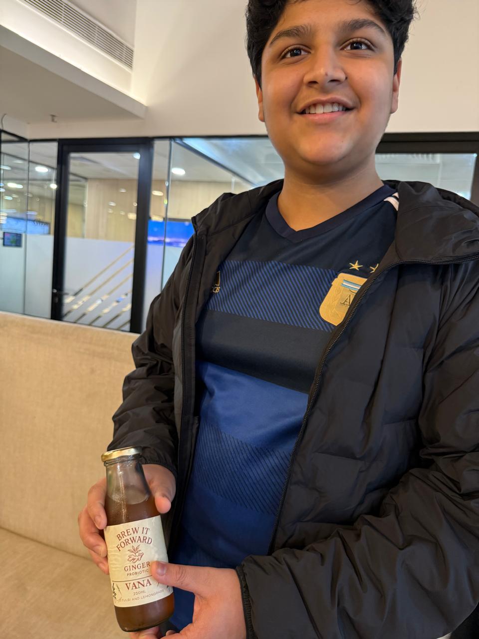 A customer holding a Brew It Forward bottle